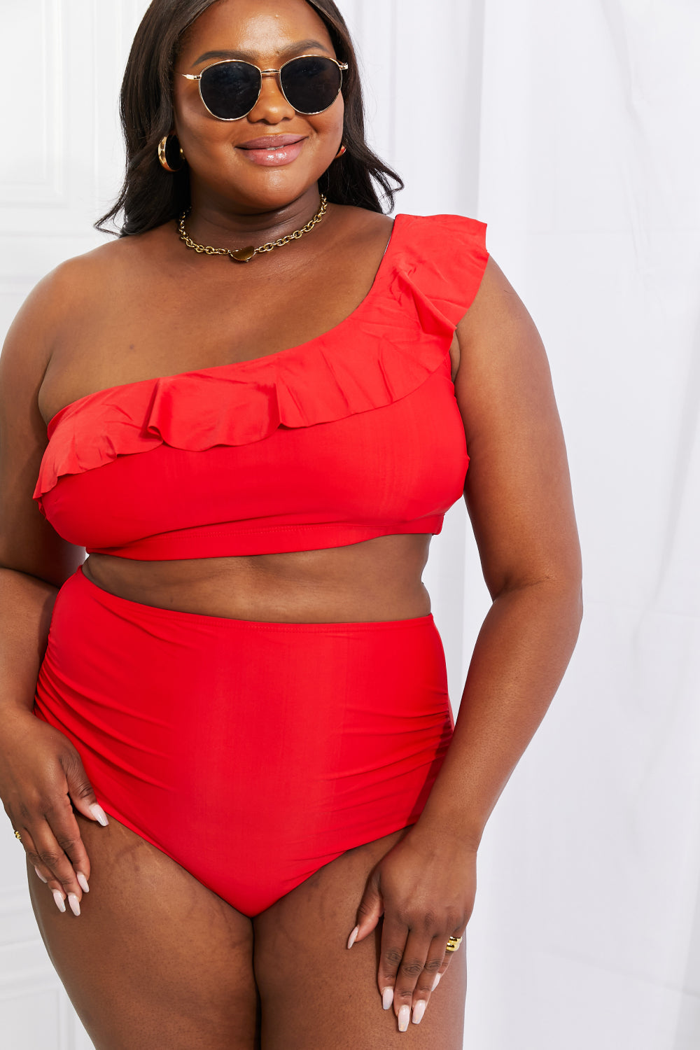 Discover elegance with the Marina West Swim Seaside Romance Ruffle One-Shoulder Bikini in Red. Perfect for the beach or pool, this two-piece set features a stylish asymmetrical top and high-waisted ruched bottoms. Enjoy comfort with removable pads and a blend of 83% polyester and 17% spandex. Ideal for confident swims and lounging in style.