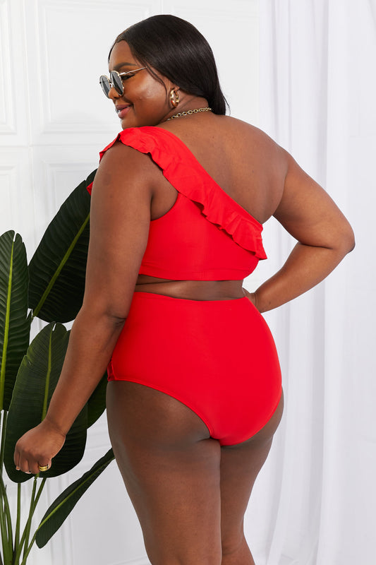 Discover elegance with the Marina West Swim Seaside Romance Ruffle One-Shoulder Bikini in Red. Perfect for the beach or pool, this two-piece set features a stylish asymmetrical top and high-waisted ruched bottoms. Enjoy comfort with removable pads and a blend of 83% polyester and 17% spandex. Ideal for confident swims and lounging in style.