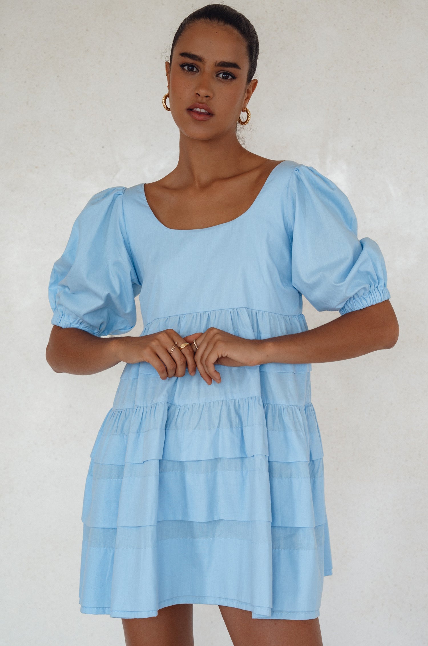 Achieve effortless femininity with the Andrea Babydoll Cotton Mini Dress. Handmade from breathable poplin cotton, this dress features elasticated sleeves, chic folds on the hem, and a flattering round neckline. 