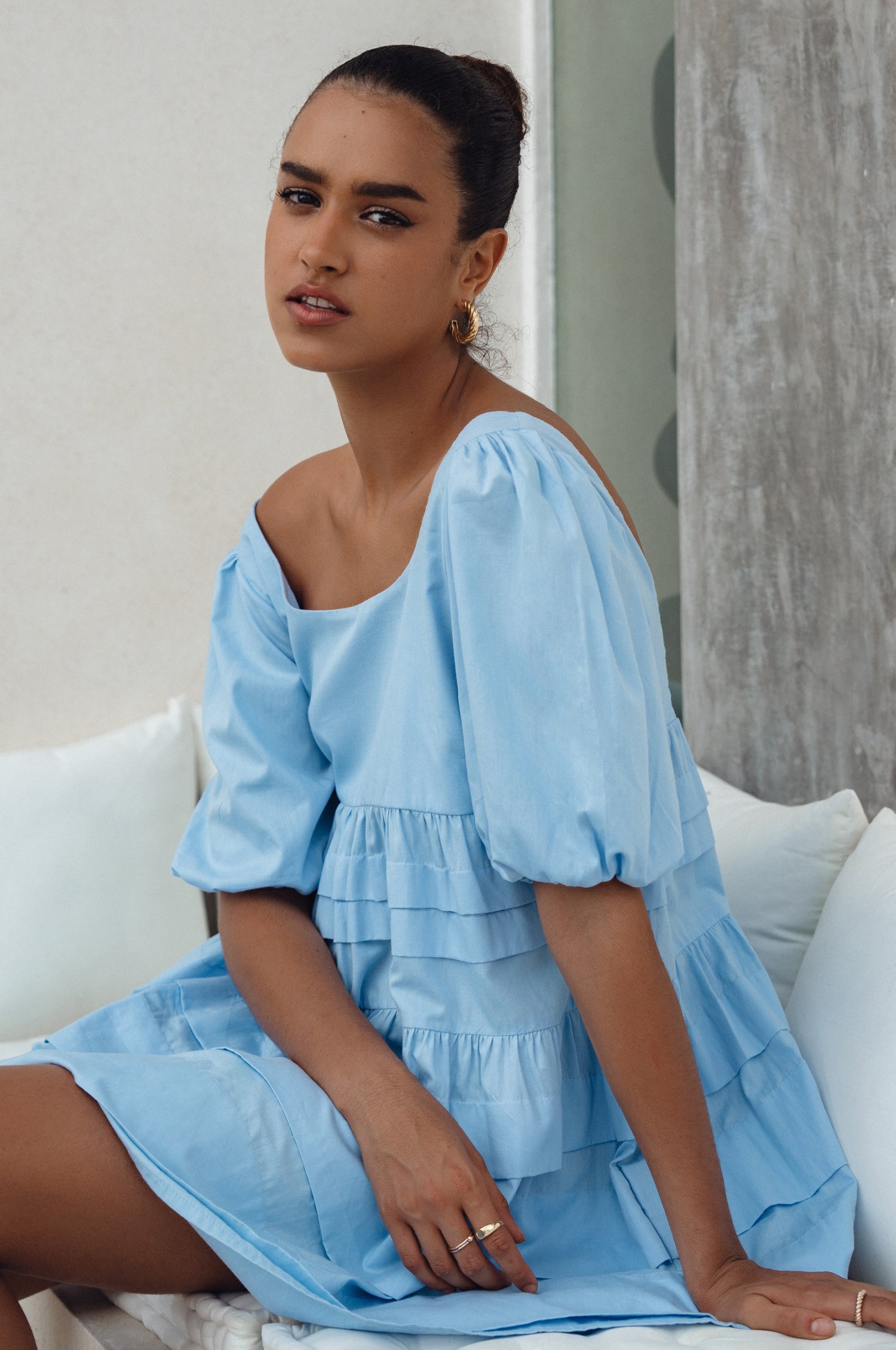 Achieve effortless femininity with the Andrea Babydoll Cotton Mini Dress. Handmade from breathable poplin cotton, this dress features elasticated sleeves, chic folds on the hem, and a flattering round neckline. 