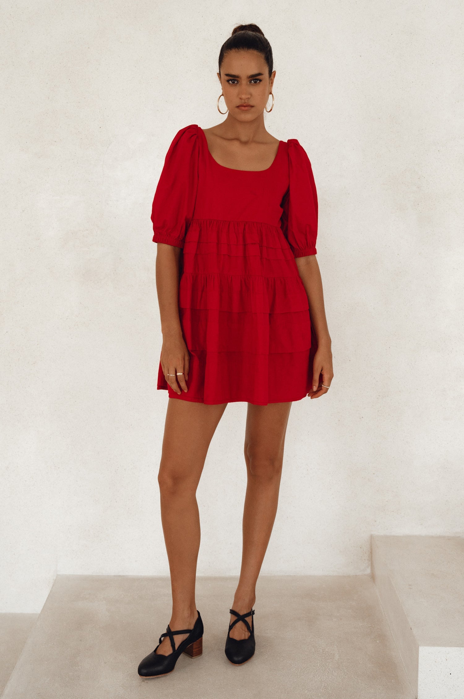 Achieve effortless femininity with the Andrea Babydoll Cotton Mini Dress. Handmade from breathable poplin cotton, this dress features elasticated sleeves, chic folds on the hem, and a flattering round neckline. 