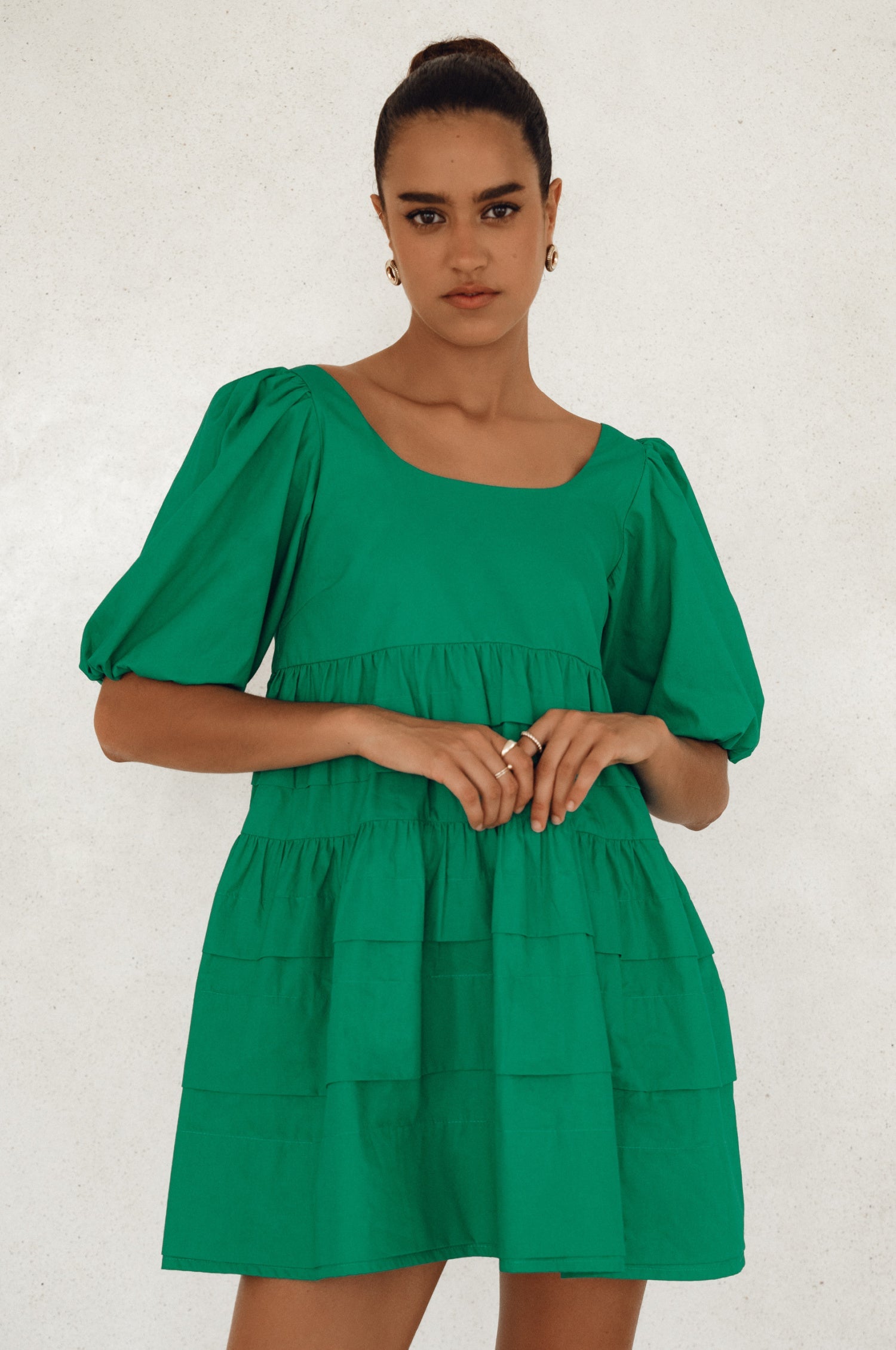 Achieve effortless femininity with the Andrea Babydoll Cotton Mini Dress. Handmade from breathable poplin cotton, this dress features elasticated sleeves, chic folds on the hem, and a flattering round neckline. 