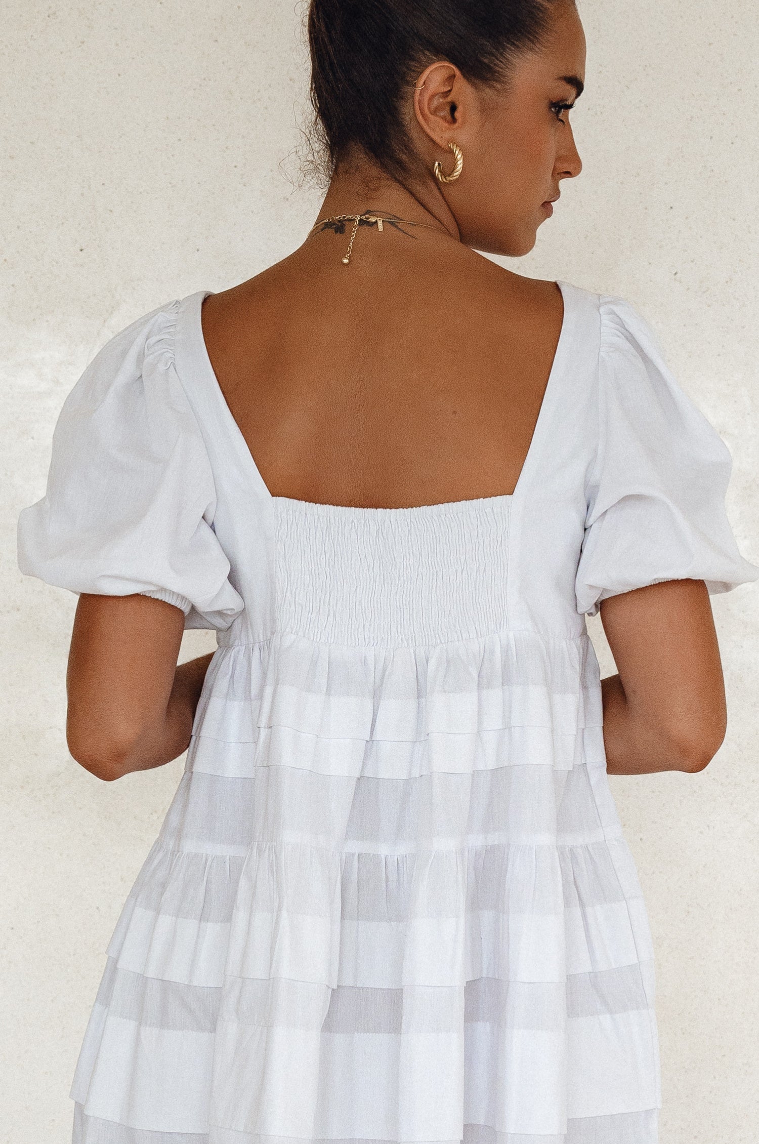 Achieve effortless femininity with the Andrea Babydoll Cotton Mini Dress. Handmade from breathable poplin cotton, this dress features elasticated sleeves, chic folds on the hem, and a flattering round neckline. 