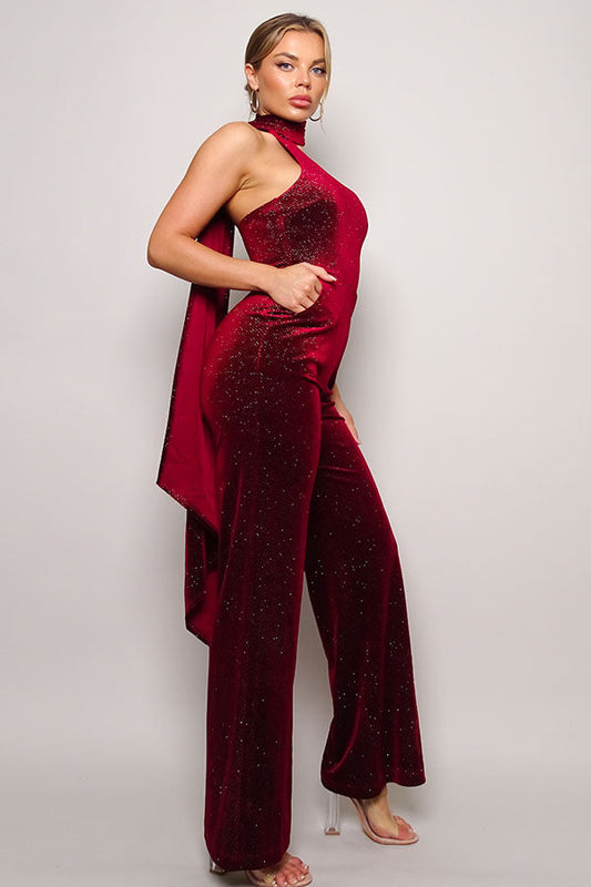 Embrace glamour in our Burgundy Glitter Velvet Jumpsuit with a chic scarf top. Perfect for a night out, this sleeveless one-shoulder outfit ensures style and comfort. Available now in the United States.