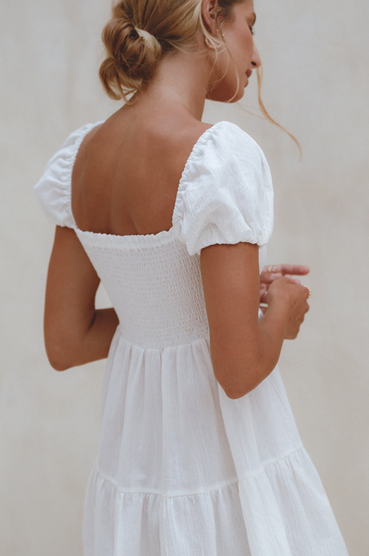 Experience effortless style with our Catalina Smocked Linen Mini Dress. Handcrafted from breathable crinkle linen, this dress features a smocked bodice, ruffles, and petite shell buttons for added elegance. Perfect for a beachside weekend with sandals or a chic lunch outing with strappy heels. 