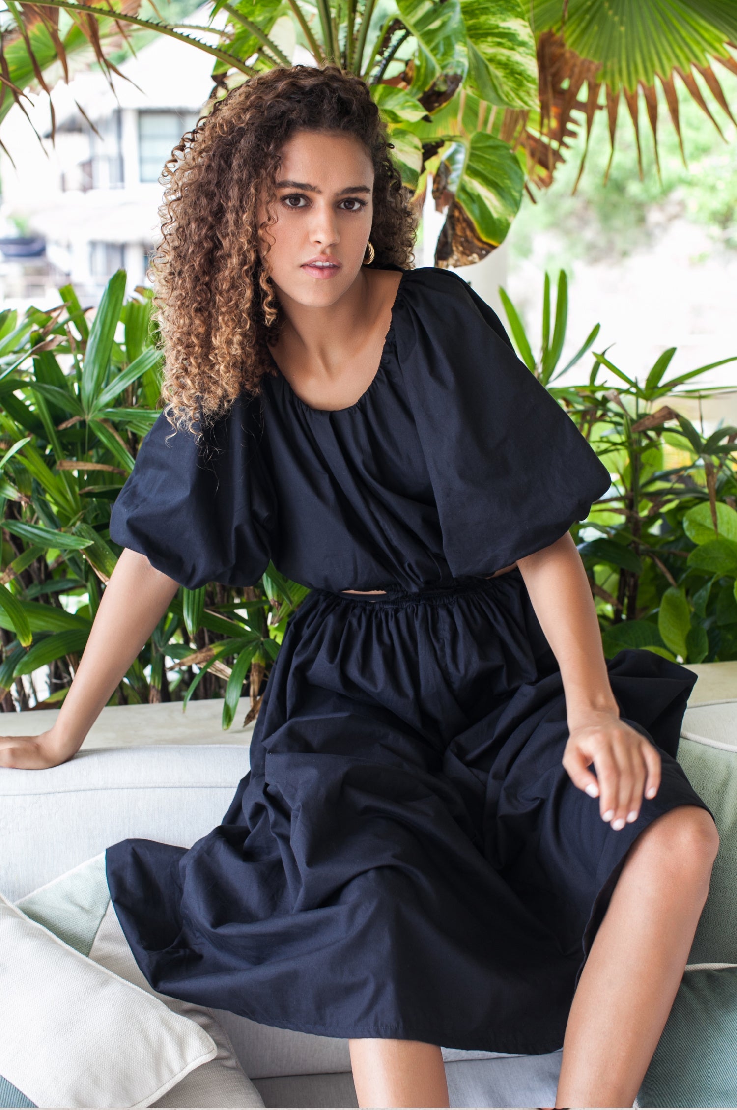 Elevate your style with the Eva Poplin Cotton Cutout Midi Dress. Handcrafted for enduring elegance, this dreamy dress features a voluminous skirt, puff sleeves, and daring cutouts at the waist with wraparound ties.