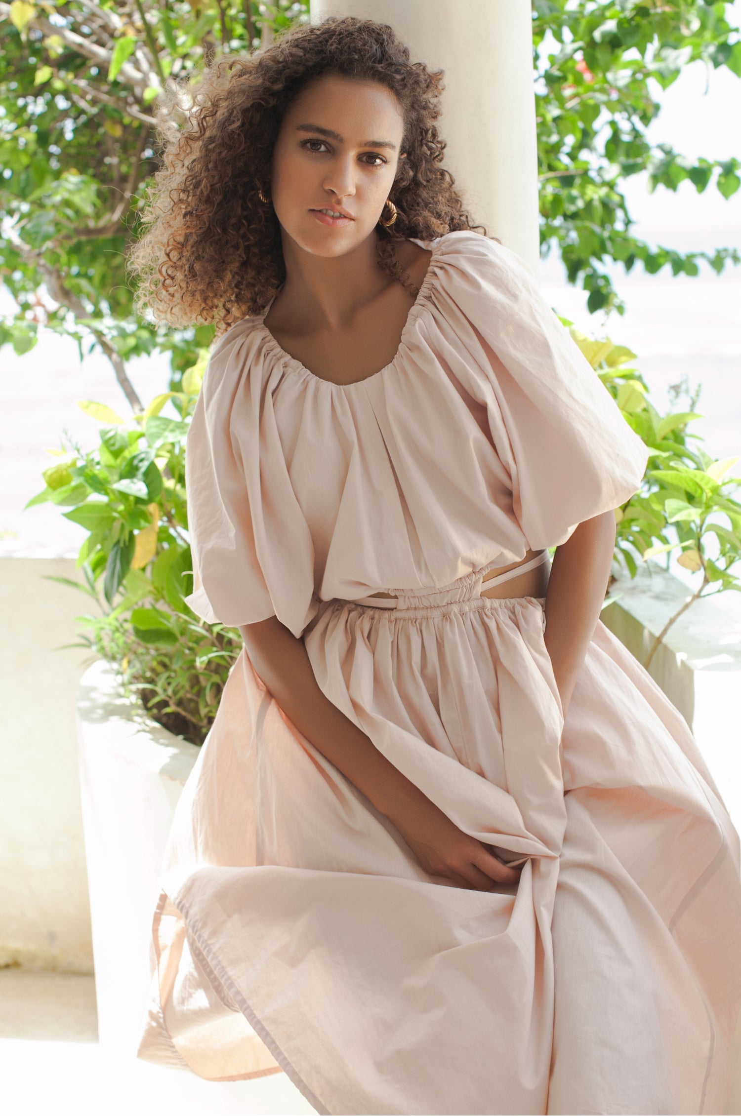 Elevate your style with the Eva Poplin Cotton Cutout Midi Dress. Handcrafted for enduring elegance, this dreamy dress features a voluminous skirt, puff sleeves, and daring cutouts at the waist with wraparound ties.