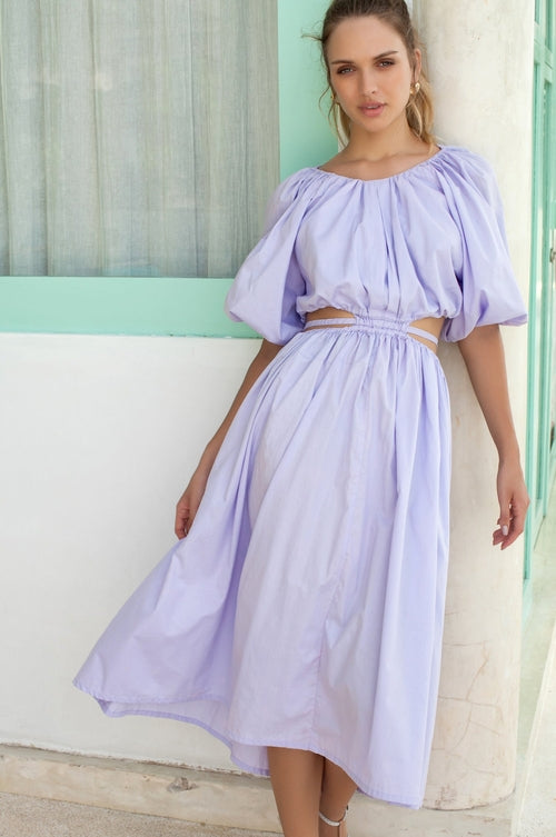 Elevate your style with the Eva Poplin Cotton Cutout Midi Dress. Handcrafted for enduring elegance, this dreamy dress features a voluminous skirt, puff sleeves, and daring cutouts at the waist with wraparound ties.