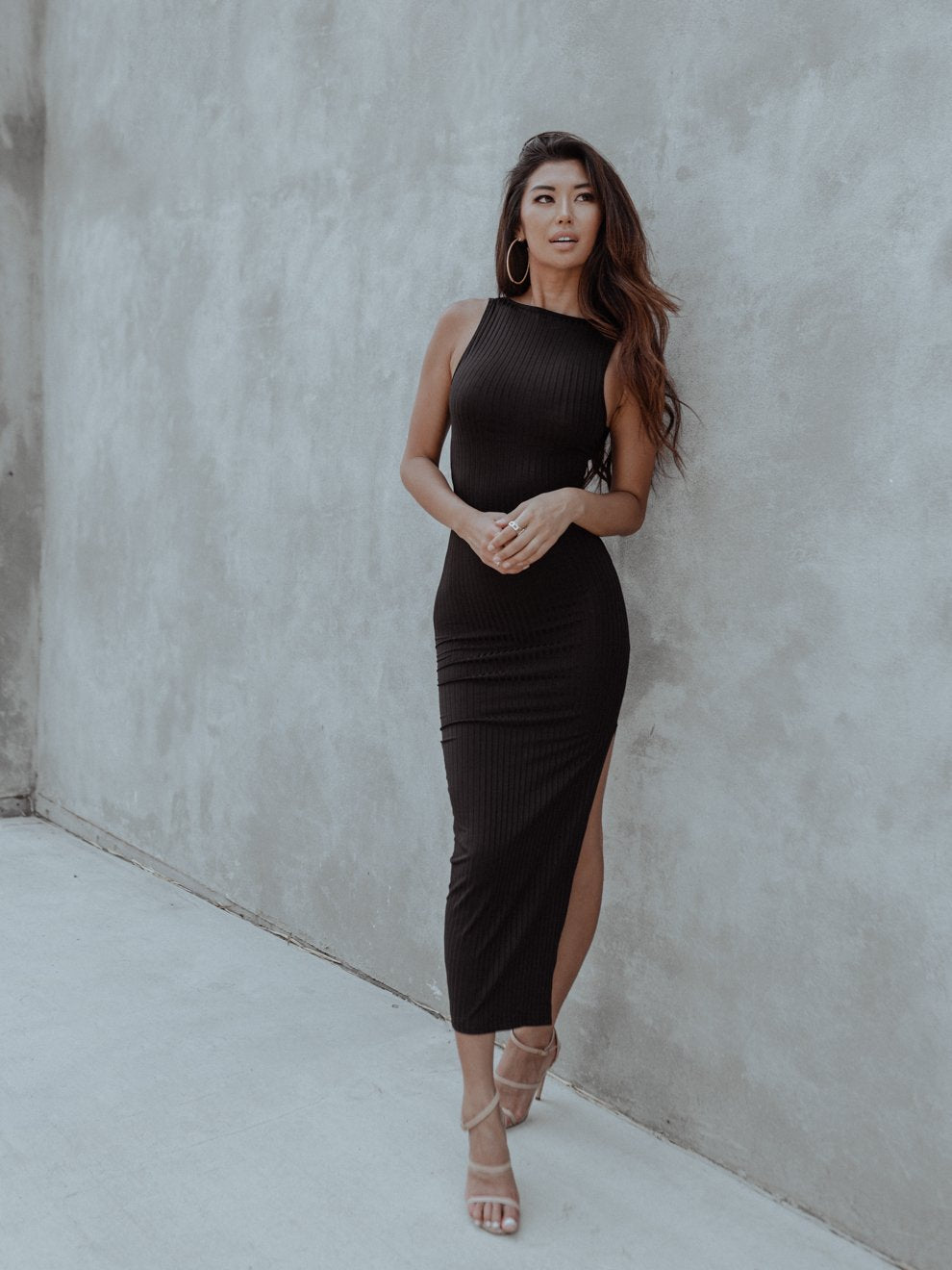 Discover versatile elegance with our Milan Cut-out Black Dress. This 2-in-1 black dress features a stylish cut-out that can be worn in the front or back. Made from lightweight ribbed knit, it hugs your curves, and the side slit adds allure. Crafted with care from 100% Polyester. 