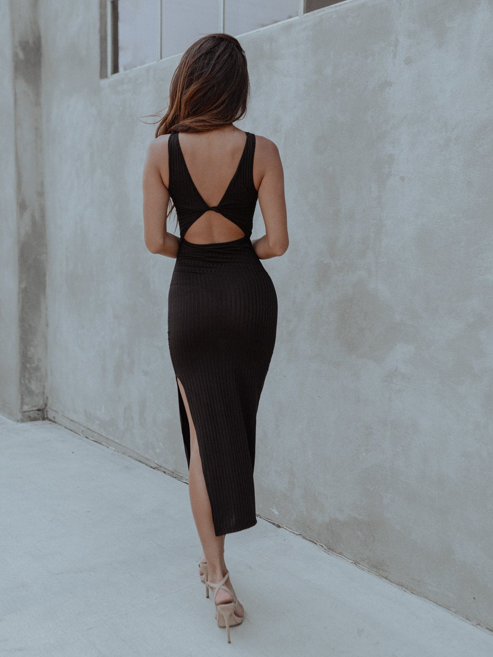 Discover versatile elegance with our Milan Cut-out Black Dress. This 2-in-1 black dress features a stylish cut-out that can be worn in the front or back. Made from lightweight ribbed knit, it hugs your curves, and the side slit adds allure. Crafted with care from 100% Polyester. 