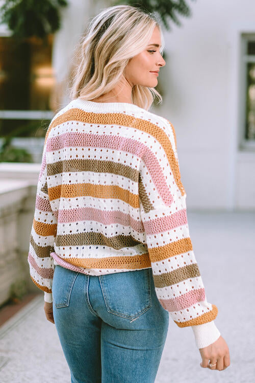 Woman wearing an elegant openwork striped round neck long sleeve knit top in 100% acrylic. Available in sizes S to XL, offering a slightly stretchy and comfortable fit. 