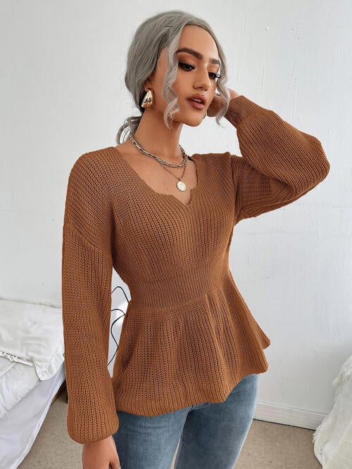 Woman wearing a chic notched dropped shoulder knit top in 100% acrylic. Available in sizes S to XL, offering a slightly stretchy and comfortable fit. Easy care with machine wash cold and tumble dry low. 