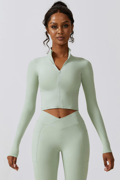 Woman wearing a zip-up long sleeve cropped active top in a highly stretchy blend of 78% nylon and 22% elastane. Available in sizes S to XL, offering a comfortable fit. Easy care with machine wash cold and tumble dry low.