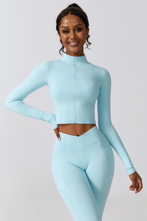 Woman wearing a zip-up long sleeve cropped active top in a highly stretchy blend of 78% nylon and 22% elastane. Available in sizes S to XL, offering a comfortable fit. Easy care with machine wash cold and tumble dry low.