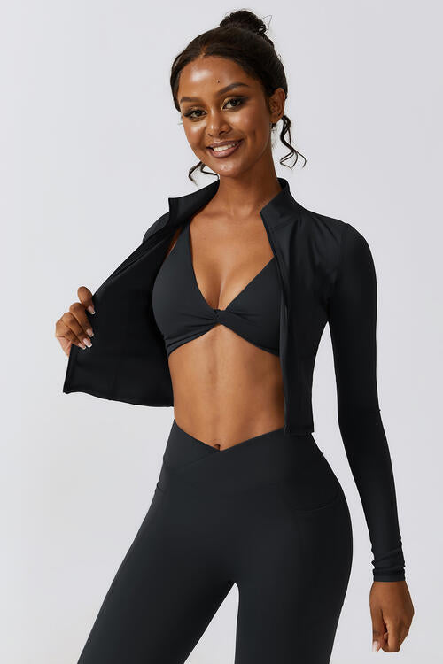 Woman wearing a zip-up long sleeve cropped active top in a highly stretchy blend of 78% nylon and 22% elastane. Available in sizes S to XL, offering a comfortable fit. Easy care with machine wash cold and tumble dry low.