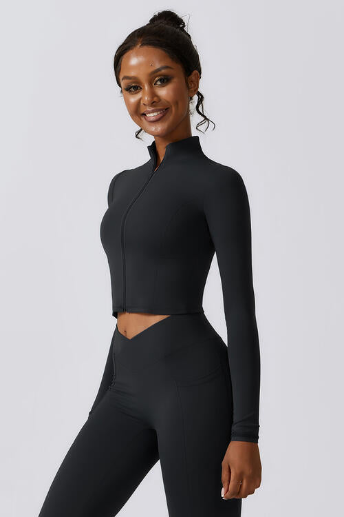 Woman wearing a zip-up long sleeve cropped active top in a highly stretchy blend of 78% nylon and 22% elastane. Available in sizes S to XL, offering a comfortable fit. Easy care with machine wash cold and tumble dry low.