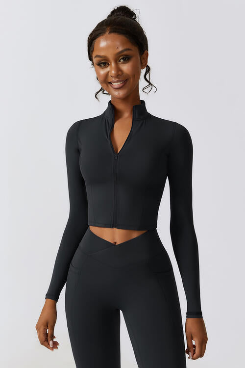 Woman wearing a zip-up long sleeve cropped active top in a highly stretchy blend of 78% nylon and 22% elastane. Available in sizes S to XL, offering a comfortable fit. Easy care with machine wash cold and tumble dry low.