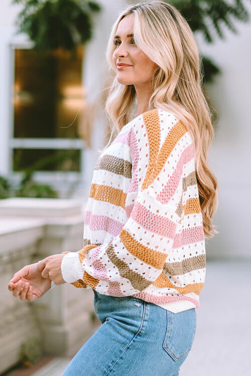 Woman wearing an elegant openwork striped round neck long sleeve knit top in 100% acrylic. Available in sizes S to XL, offering a slightly stretchy and comfortable fit. 