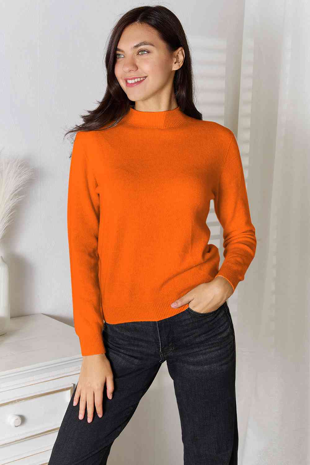 Woman wearing a classic mock neck long sleeve knit top in 100% wool, perfect for winter. Available in sizes S to 2XL.