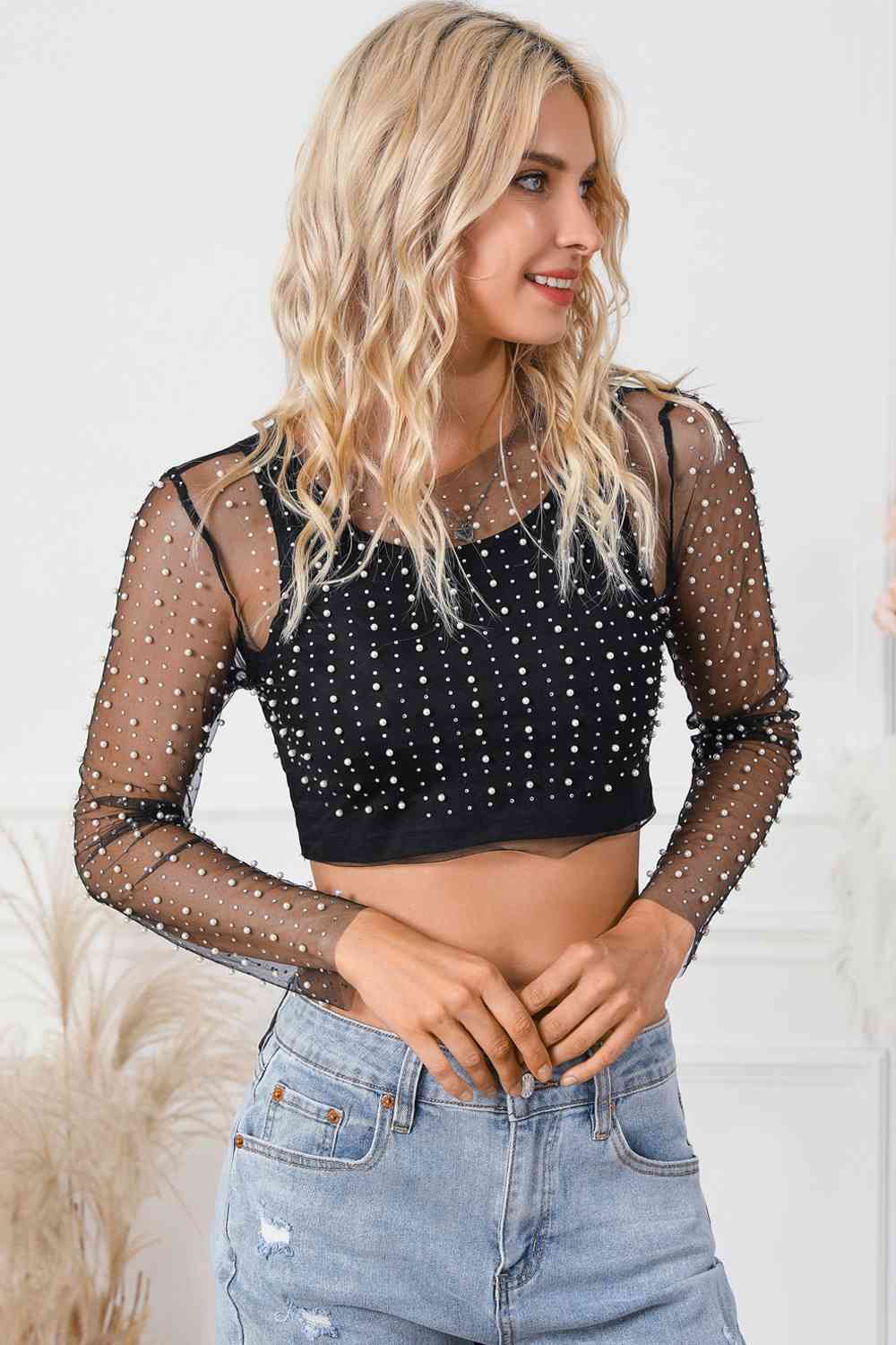 Elegant Pearl Long Sleeve Mesh Cropped Top with rhinestone detailing. Made from a blend of polyester and elastane. Semi-sheer and slightly stretchy for a sophisticated look. Available in sizes S to XL.