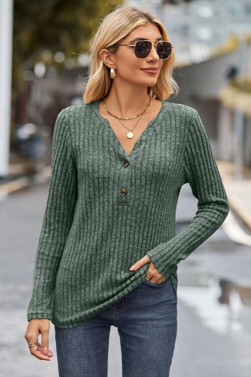 Woman wearing a chic ribbed half button long sleeve knit top in a blend of 60% polyester, 35% rayon, and 5% spandex. Available in sizes S to 2XL, offering slight stretch for comfort