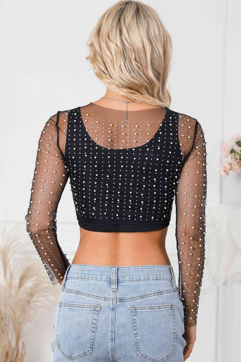 Elegant Pearl Long Sleeve Mesh Cropped Top with rhinestone detailing. Made from a blend of polyester and elastane. Semi-sheer and slightly stretchy for a sophisticated look. Available in sizes S to XL.